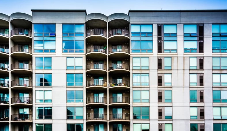 Modern apartment building exterior with large windows and landscaped surroundings in Minnesota.