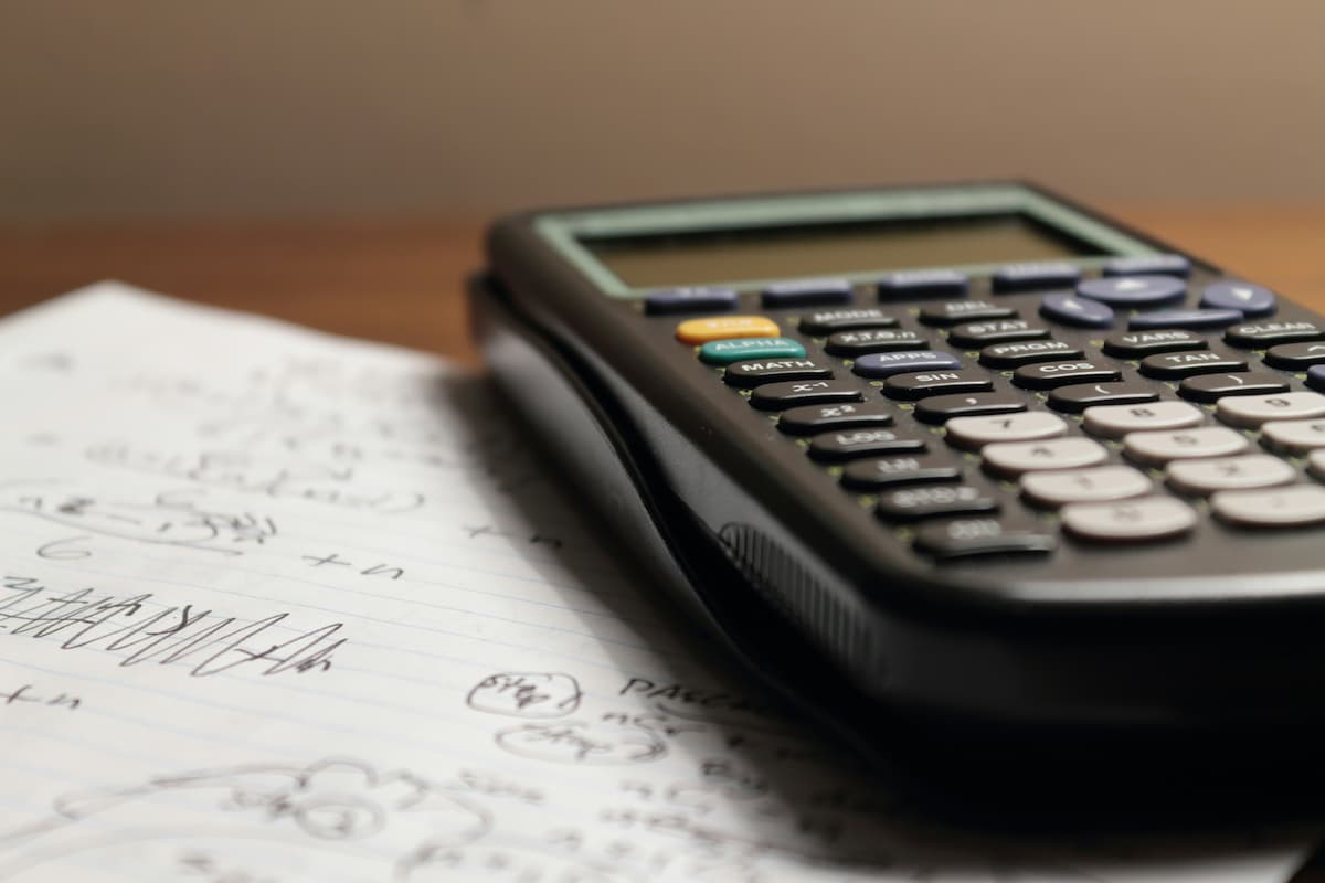 A calculator and financial documents used to estimate cash flow on a rental property.