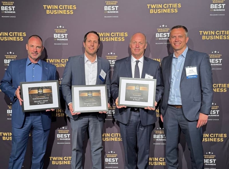 Four Security Bank & Trust Co. leaders holding three Twin Cities Business best-in-business awards