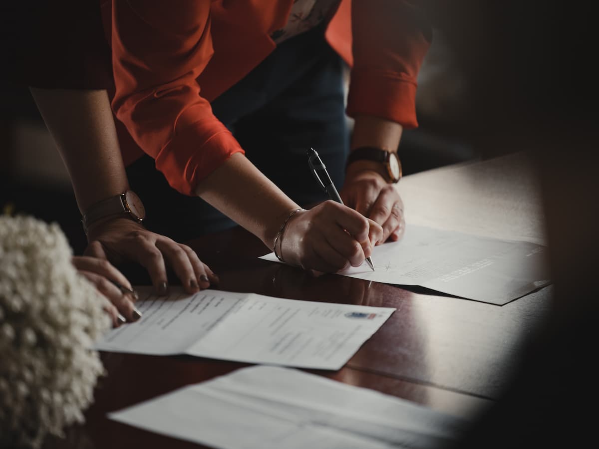 Two people reviewing and signing loan documents at a table