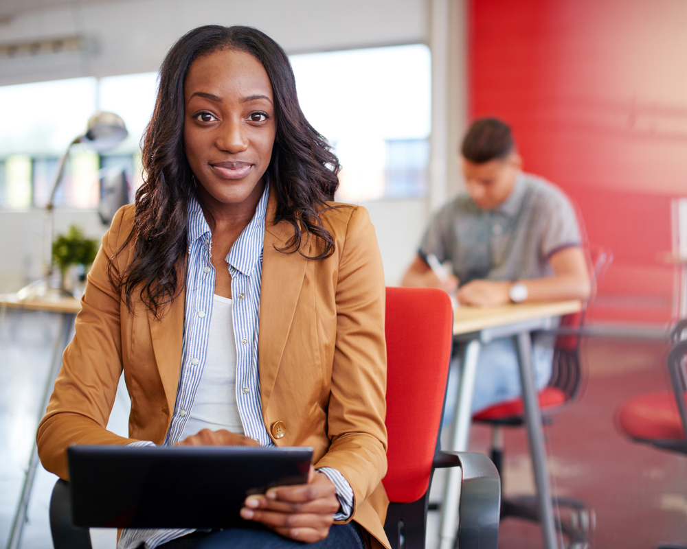 Confident female designer working on a digital tablet in red creative office space-2