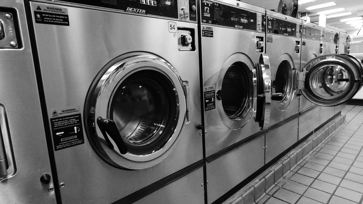 Folded laundry stacked on a table in a laundromat