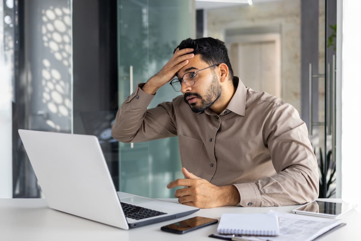 stressed laptop user holding his forehead